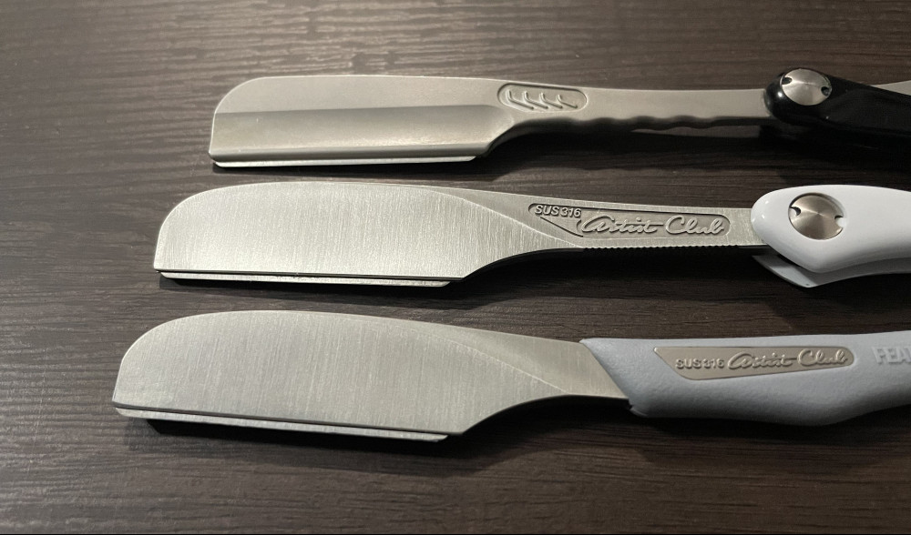 Picture showing the hairline stainless finish on the two DX razors (middle and bottom) and the SS razor top.