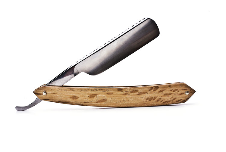 A partially open straight razor with a light-colored, wooden handle and decorative markings on the spine