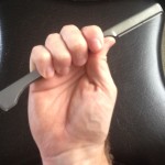An image of a right hand holding shavette with full grip