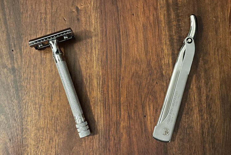 A Merkur 180 long handle safety razor and a Dovo shavette sitting on a wooden surface